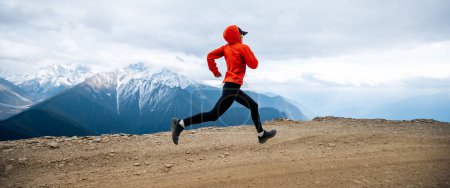 Femme trail runner cross country courir à haute altitude montagnes