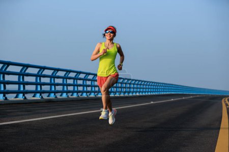 Fitnessläuferin läuft auf Seebrücke