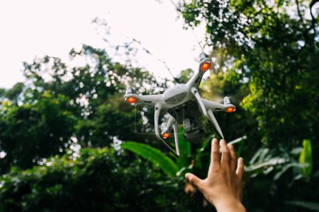 Téléchargez les photos : Main et drone blanc avec caméra volant dans les montagnes d'été - en image libre de droit