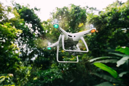 Foto de Drone blanco con cámara volando en el bosque de verano - Imagen libre de derechos