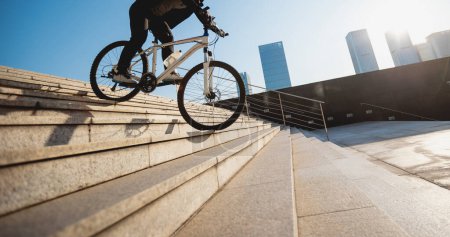 Photo for Woman free rider riding bike going down city stairs - Royalty Free Image