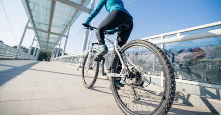 Foto de Mujer montar en bicicleta en la ciudad en el día soleado - Imagen libre de derechos