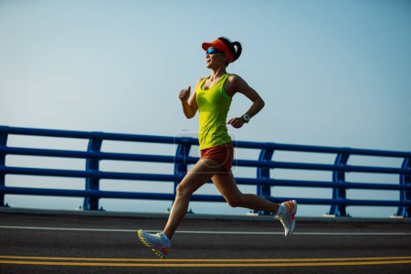 Photo for Fitness woman runner running on seaside bridge - Royalty Free Image