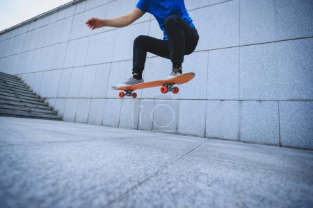 Téléchargez les photos : Femme asiatique skateboarder skateboard dans la ville moderne - en image libre de droit