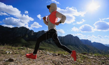 Woman ultramarathon runner running at mountain top
