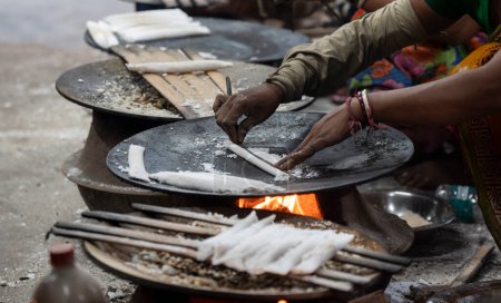 Téléchargez les photos : Women fait pitha traditionnelle assamaise (gâteau de riz) avant Magh Bihu, également connu sous le nom de festival Bhogali Bihu, le 8 janvier 2024 à Guwahati, Assam, Inde. Magh Bihu, également connu sous le nom de Bhogali Bihu, est une fête de la récolte célébrée en Assam. - en image libre de droit