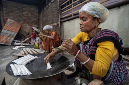 Téléchargez les photos : Vendeur vendant des aliments traditionnels assamais dans un marché, avant le festival Magh Bihu à Guwahati, Assam, Inde, le 13 janvier 2024. Magh Bihu marque la fin de la saison de récolte, en particulier la récolte du riz. - en image libre de droit
