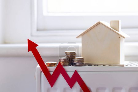Die Heizkosten für Eigenheime steigen. Roter Pfeil mit einem Haus auf einem Heizkörper.