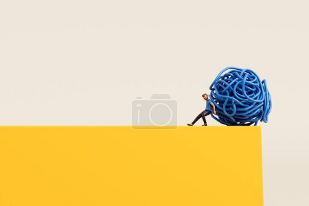 Foto de Una persona empujando una bola enredada de cuerda desde un borde del acantilado. Deshacerse del estrés y los problemas. Renderizado 3D. - Imagen libre de derechos