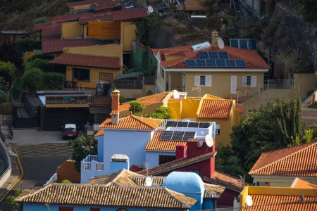 Foto de Paneles solares sobre techos de casas en un pueblo. Alrededor de la vegetación. Ecología, energía verde, salvar el planeta. - Imagen libre de derechos