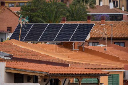 Foto de Grupo de paneles solares en el techo de casas unifamiliares. Paneles solares. Energía limpia. Ecología. Tejas rojas. Tenerife, Islas Canarias, España - Imagen libre de derechos