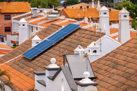 Foto de Grupo de paneles solares antiguos y paneles solares de nueva tecnología en el techo de casas unifamiliares. Paneles solares. Energía limpia. Ecología. Tejas rojas. Tenerife, Islas Canarias, España - Imagen libre de derechos