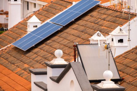 Foto de Grupo de paneles solares en el techo de casas unifamiliares. Paneles solares. Energía limpia. Ecología. Tejas rojas. Tenerife, Islas Canarias, España - Imagen libre de derechos