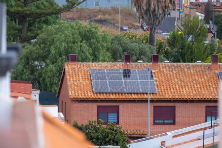 Téléchargez les photos : Panneaux solaires sur le toit d'une maison unifamiliale avec briques rouges et tuiles rouges. Tenerife, Îles Canaries, Espagne - en image libre de droit