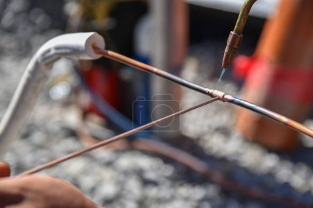 Photo for On the construction site, craftsmen works brazing copper wire - welding - Royalty Free Image