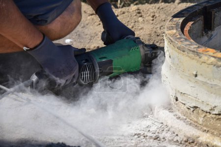 Craftsman cuts on construction site with angle grinder stone - craftsman