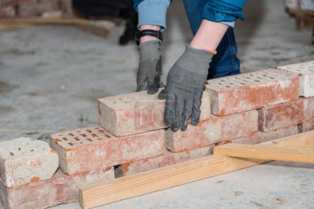 Photo for Craftsman builds wall with bricks - mason with chimney bricks - Royalty Free Image