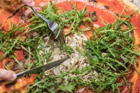 Photo for Vegan and vegetarian pizza is eaten - pizza with rocket, mushrooms, zucchini and aubergine - Royalty Free Image