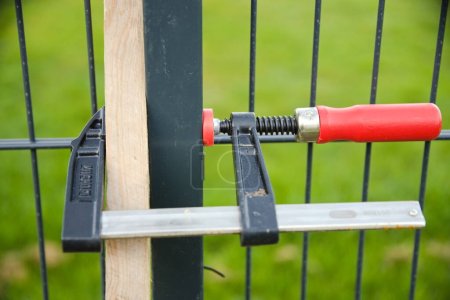 Foto de Utilice abrazaderas de tornillo para fijar la valla del jardín al instalar cercas de jardín - Imagen libre de derechos