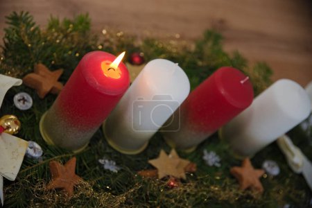 Stimmungsvolles Kerzenlicht erstrahlt auf dem Adventgesteck - die erste Kerze brennt, Advent