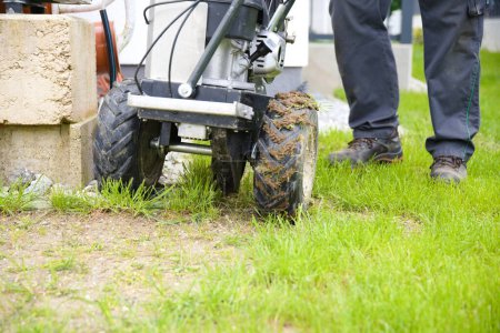 Gärtner verlegt mit Kabelverlegemaschine Grenzdraht für Rasenmäherroboter - Nahaufnahme
