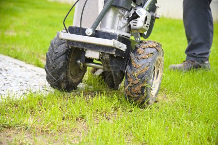 Photo for Gardener with laying aid for boundary wire of a robot lawn mower - close-up - Royalty Free Image