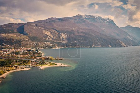 Foto de Panorama de Torbole una pequeña ciudad en el lago de Garda, Italia. Europa.Hermoso lago de Garda rodeado de montañas en la primavera visto desde el Monte Brione - Imagen libre de derechos