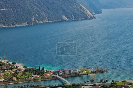 Foto de Panorama de Torbole una pequeña ciudad en el lago de Garda, Italia. Europa.Hermoso lago de Garda rodeado de montañas en la primavera visto desde el Monte Brione - Imagen libre de derechos
