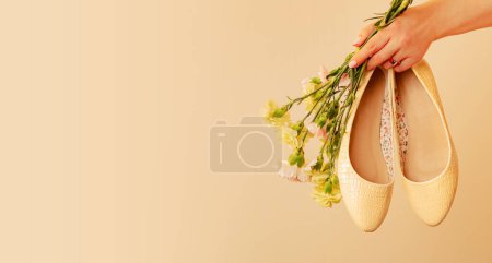 Photo for Spring shoes banner background. Fashion - footwear for woman. Pastel yellow ballet flats (ballerinas) and flowers on beige. Free copy (text) space. - Royalty Free Image