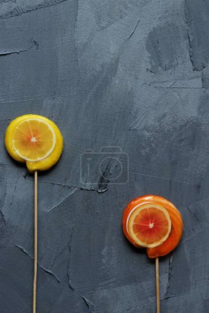 Téléchargez les photos : Sucettes orange et citron sur fond gris - en image libre de droit