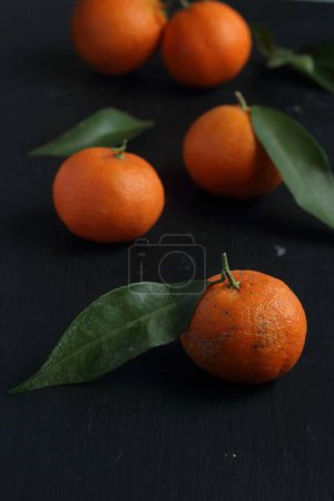 Téléchargez les photos : Groupe de mandarines sur fond noir - en image libre de droit