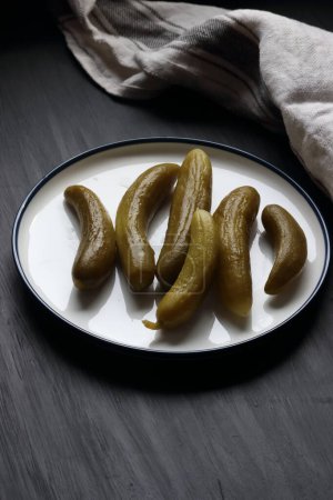 Téléchargez les photos : Marinade de concombre dans une assiette sur un fond noir - en image libre de droit