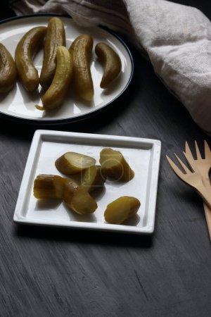 Téléchargez les photos : Cucumber pickle in a plate on a black background - en image libre de droit
