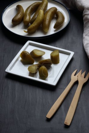 Photo for Cucumber pickle in a plate on a black background - Royalty Free Image