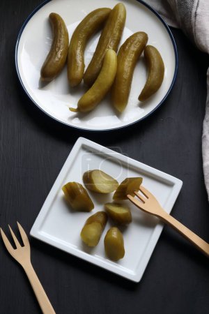 Téléchargez les photos : Cucumber pickle in a plate on a black background - en image libre de droit