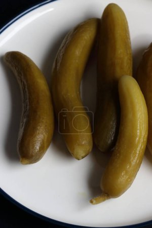 Téléchargez les photos : Concombre cornichons sur une assiette sur un fond noir - en image libre de droit