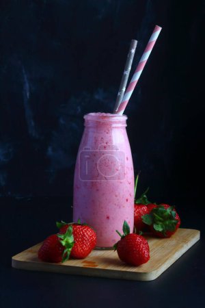 Téléchargez les photos : Smoothie aux fraises sur fond noir - en image libre de droit