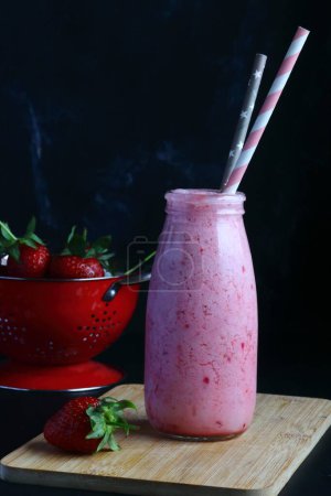 Téléchargez les photos : Smoothie aux fraises sur fond noir - en image libre de droit