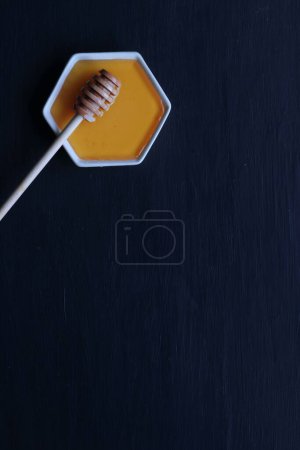 Photo for Fresh Honey with wooden honey spoon on a black background - Royalty Free Image