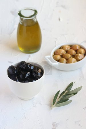 Photo for Green and black olives , oilve oil and olive leaves on  a white background - Royalty Free Image