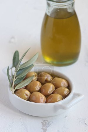 Photo for Green olives , olive oil and olive leaves on a white background - Royalty Free Image