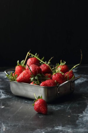 Photo for Strawberries on a black background, strawberries in a metal bowl - Royalty Free Image