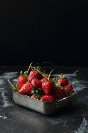Foto de Fresas sobre fondo negro, fresas en un cuenco de metal - Imagen libre de derechos