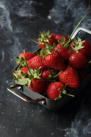 Photo for Strawberries on a black background, strawberries in a metal bowl - Royalty Free Image