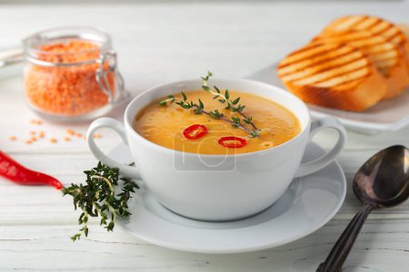 Téléchargez les photos : Purée de soupe de lentilles rouges fraîches sur une table en bois. Vue d'en haut. - en image libre de droit