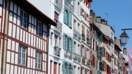 Téléchargez les photos : Façades vintage colorées de maisons basques françaises typiques avec volets et fenêtres de couleurs décolorées au centre-ville de Bayonne, Pays basque, Espagne. Vue panoramique. - en image libre de droit