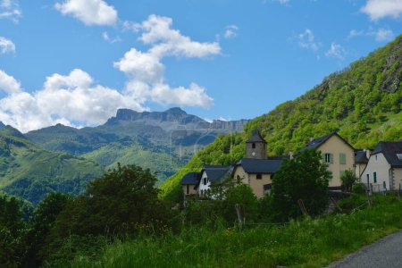 Cozy distant village against vivid mountain landscape. Highland France, Pyrenees mountain range.