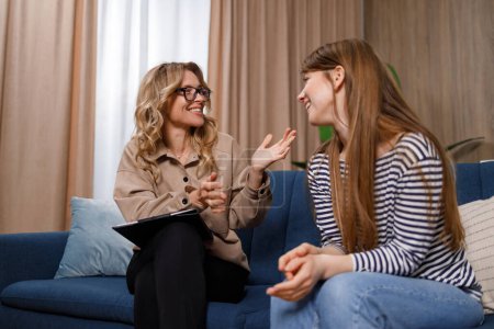 Ermutigende Therapeutin spricht mit junger Frau