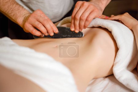 Photo for Male chiropractor is treating woman abdominal muscles by IASTM technology - Royalty Free Image