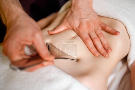 Photo for Stomach area massage with special metal instrument - Royalty Free Image